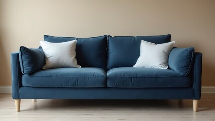 Fototapeta premium Blue sofa with white pillows in living room, beige wall, daytime