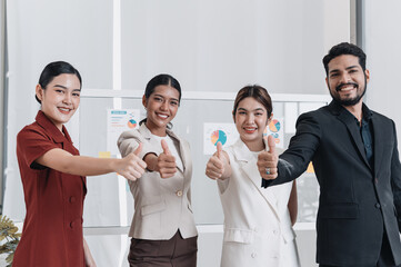 Group of confident business professionals smiling and showing thumbs up, representing success, teamwork, positive results, and achievement in the workplace.