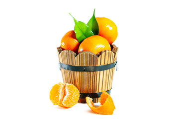 Juicy shiny tangerines with slices and leaves in a wooden tub isolated on a white background.