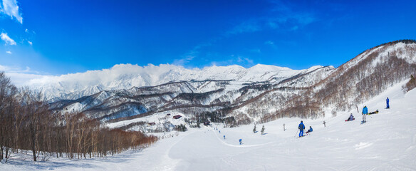 A stunning view of the cloud-covered Hakuba Sanzan mountain range from a ski slope (Tsugaike Kogen, Hakuba, Nagano, Japan)