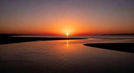 Fototapeta premium Stunning sunset reflecting on calm water with vibrant orange and purple hues, serene views