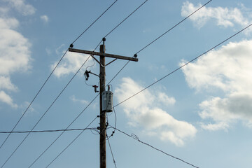 high voltage power lines with transformer and blue sky