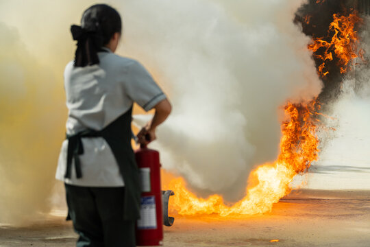 Showing how to use a fire extinguisher on a training fire for employees industry.Basic fire fighting and evacuation fire drill simulation training for safety industrial.Fire fighter concept.