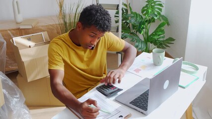 Young man calculating domestic bills at home - Powered by Adobe