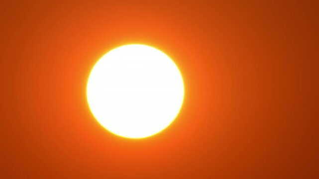 Cinematic sun set with red yellow and orange sky timelapse. Yellow sun setting at epic golden hour time lapse. Close up view of big round sun disk. Hot summer atmosphere at heat wave.
