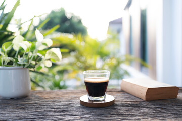 americano coffee glass cup and old book on rustic wooden table
