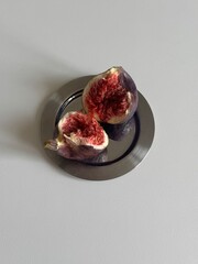 fig cut in half on a plate  on a white background