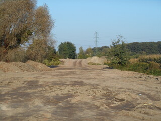 Flat terrain, newly leveled. Trees in the background.