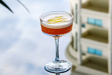 A sophisticated cocktail presented in a clear stemmed glass with garnished fresh fruit. The scene exudes elegance and refinement, perfect for luxury dining, celebrations, or social gatherings.