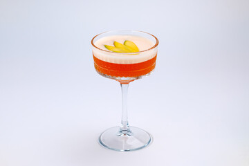 A sophisticated cocktail presented in a clear stemmed glass with garnished fresh fruit. The scene exudes elegance and refinement, perfect for luxury dining, celebrations, or social gatherings.