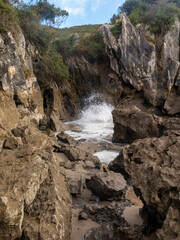Waves crashing on rocks in asturias, spain, scenic coastal landscape
