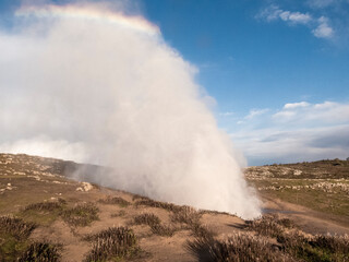 Bufones de pria showing marine geyser erupting water and creating rainbow in asturias, spain