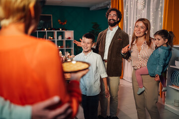 Family surprising grandmother with birthday cake at home