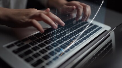 A close-up view of hands typing on a laptop keyboard with a digital data chart overlay, showcasing themes of growth, innovation, and modern technology in business. Copula