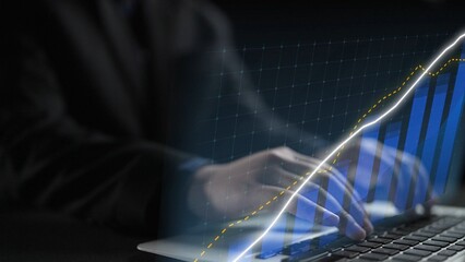 A business professional analyzes financial data on a laptop, highlighting growth trends through dynamic graphs and charts in a modern office setting. Copula