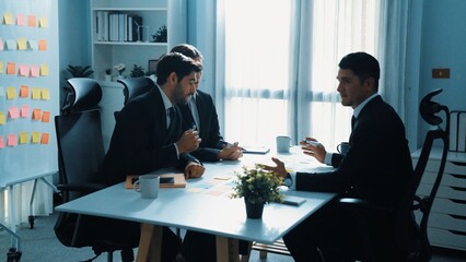 Top view of businessman discuss about business plan with caucasian manager while investor join meeting. Female leader present start up project while sitting at table with sticky notes. Directorate.