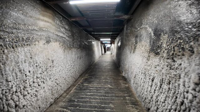 Transylvania, Romania, Aug 12, 2025: Salt-covered walls lining a walkway inside the Salina Turda salt mine in Transylvania, Romania, create a unique and captivating subterranean landscape
