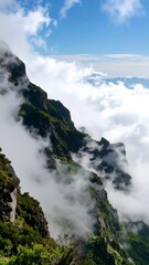 Misty mountain peaks rise above the clouds