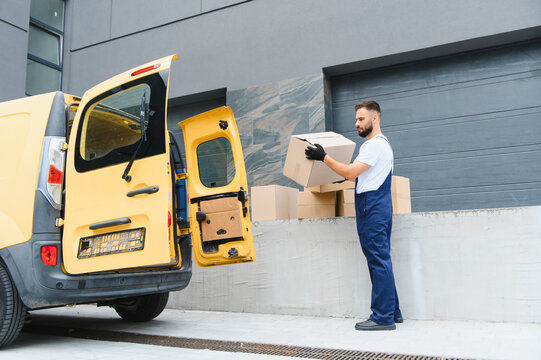 Courier loading cardboard boxes into delivery van - Powered by Adobe