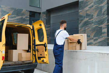 Courier unloading cardboard boxes from delivery van