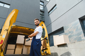 Deliveryman unloading cardboard boxes from yellow van
