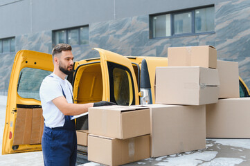 Courier checking cardboard boxes on top of delivery van