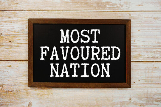 Most Favoured Nation text with gift box present and alarm clock on black background