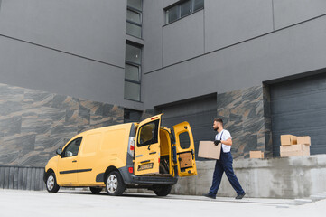 Courier carrying cardboard box from delivery van