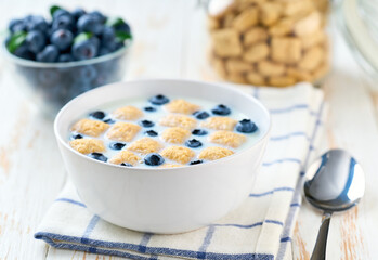 breakfast with crispy corn pads and blueberry on a white wooden table, selective focus.