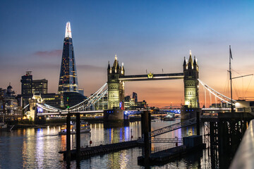 Tower Bridge illuminated in the early evening with a stunning pink sunset in background