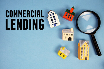Commercial Lending text with house models and magnifying glass on blue background