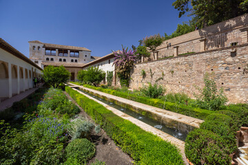 Fototapeta premium Alhambra Gardens showcasing moorish architecture and lush vegetation in Granada, Spain