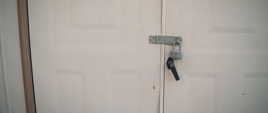 White door with padlock and metal latch