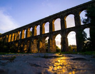 Ancient stone aqueduct at sunset
