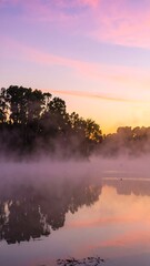 Misty sunrise over a tranquil lake