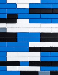 Abstract wall pattern of blue, black, and white bricks