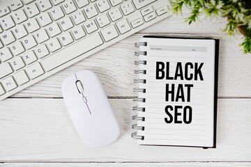 Black Hat SEO text with keyboard and wireless mouse on wooden background