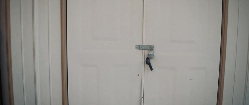Closed white door with metal latch and padlock