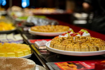 Close up of assorted cakes and pastries displayed on buffet table.
