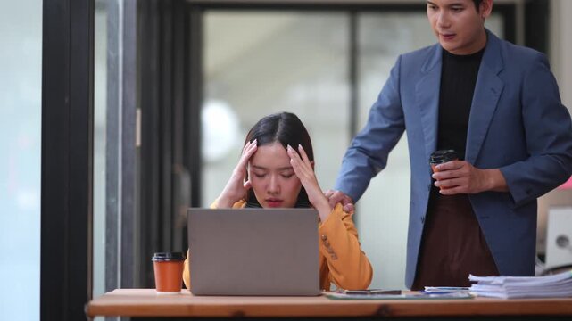 Stressed professional receiving empathetic support from coworker near workstation, showing workplace emotional struggle and compassion