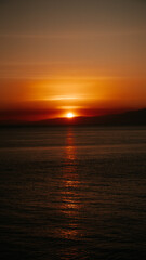 Beautiful sunset creating an aesthetically view in a combination of red, yellow, orange colors and patterns overlooking the ocean, peaceful and calm