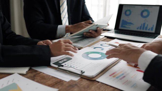Corporate team reviewing financial charts, analyzing market trends, strategizing investment approaches in modern conference room setting - Powered by Adobe
