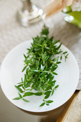 Green wedding blessing twig on white plate traditional symbol of faith and family ritual detail in catholic christian ceremony preparation before marriage