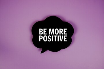 Be More Positive text with speech bubble top view on purple background