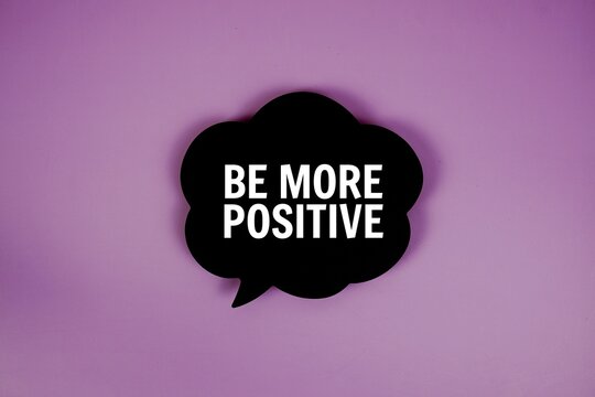 Be More Positive text with speech bubble top view on purple background