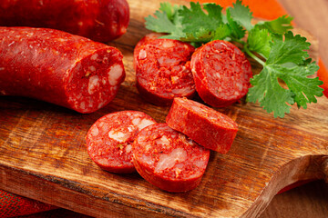 spicy Chorizo sausage, on a cutting board, on a wooden table.