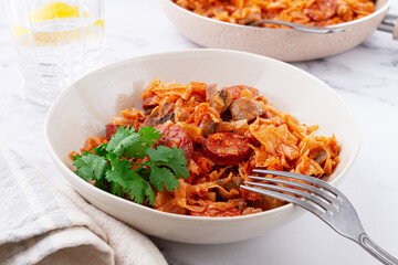 Bigos, Polish dish bigos, on the table, pan with stewed meat, with cabbage, chorizo sausages, mushrooms, homemade, without people,