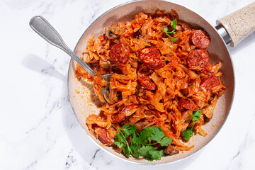 Bigos, Polish dish bigos, on a marble table, stewed meat with cabbage, chorizo sausages, mushrooms, homemade, without people,