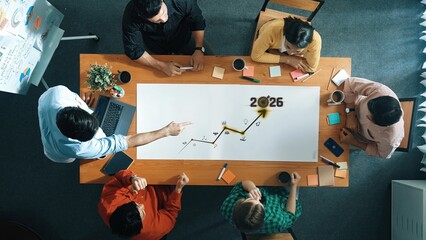 An overhead view of a collaborative team meeting, showcasing individuals discussing growth...