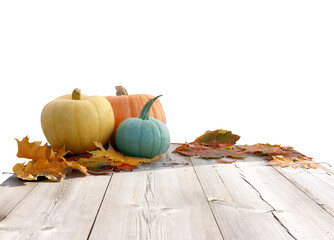 Fresh ripe pumpkins and autumn leaves on wooden table isolated
